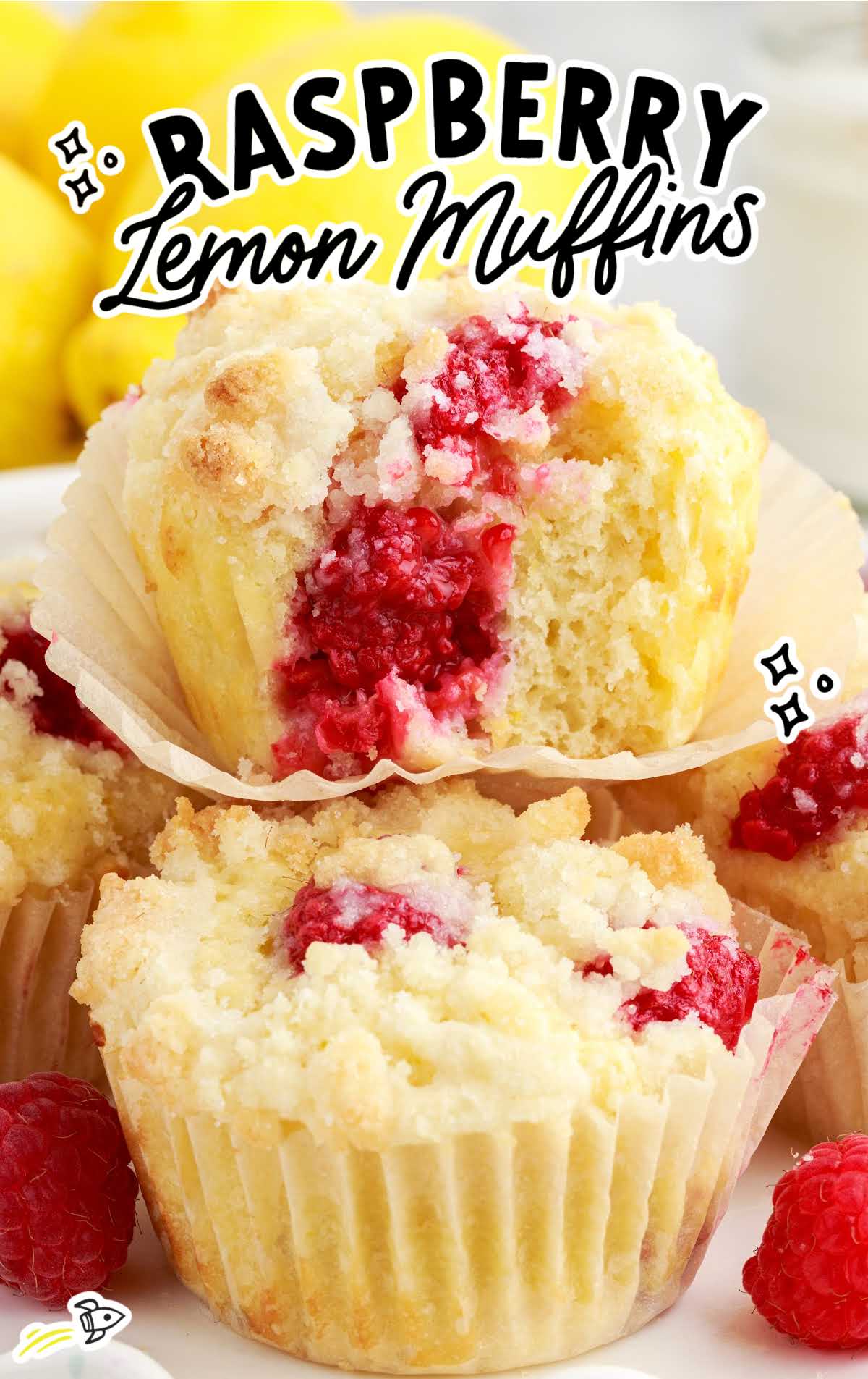 a close up shot of Raspberry Lemon Muffins with one having a bite taken out if it