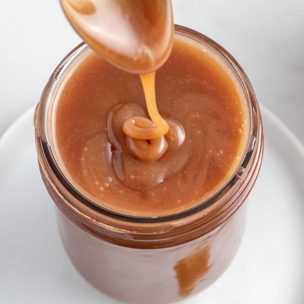 a close up shot of Salted Caramel Sauce in a mason jar