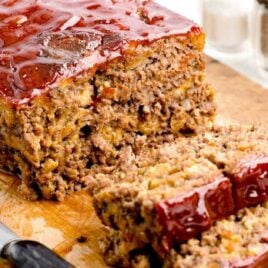 a close up shot of Stove Top Meatloaf with a pieces cut out on a wooden board