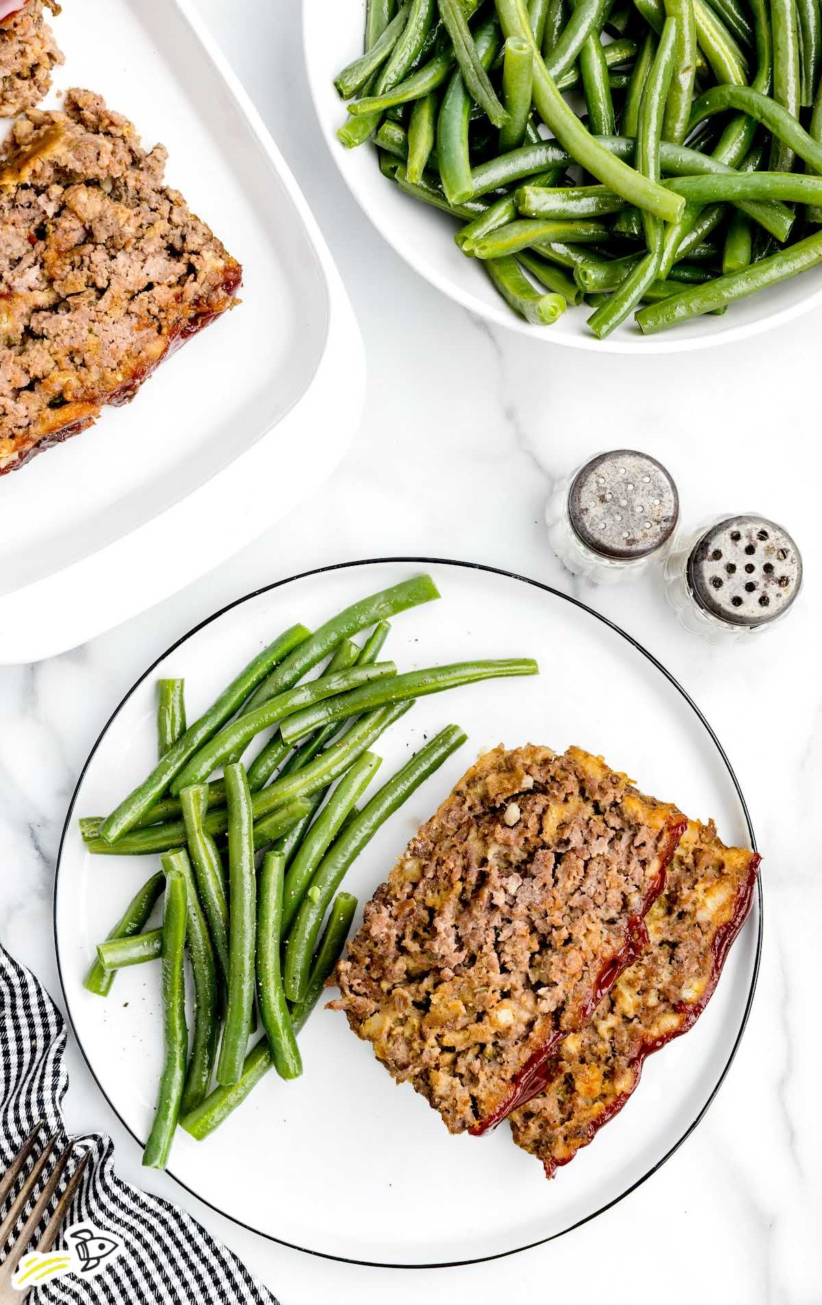 a overhead shot of a piece of Stove Top Meatloaf on a plate with green beans