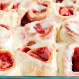 a close up shot of Strawberry Cinnamon Rolls in a baking dish