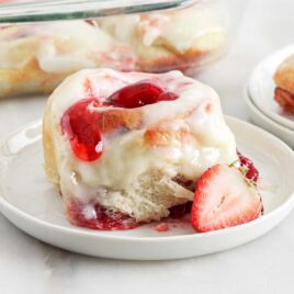a close up shot of a slice of Strawberry Cinnamon Rolls on a plate