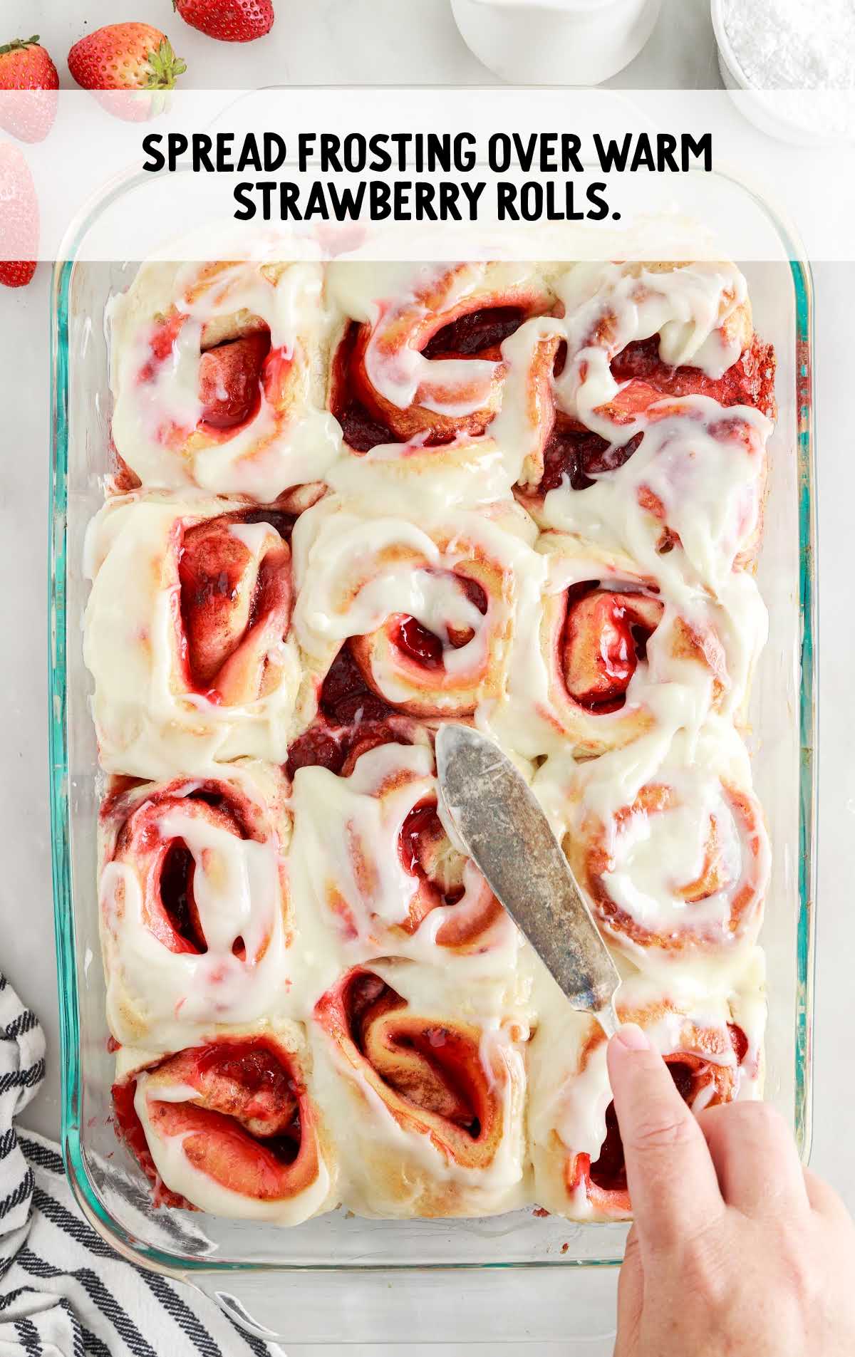 frosting spread over strawberry rolls