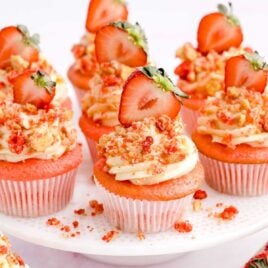 a close up shot of Strawberry Crunch Cupcakes on a stand