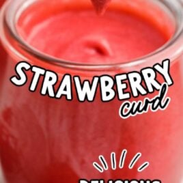 a close up shot of Strawberry Curd in a glass cup with a spoon grabbing a piece