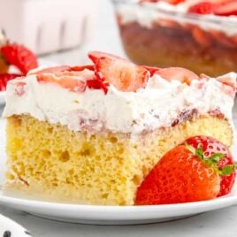 a close up shot of a slice of Strawberry Tres Leches Cake on a plate
