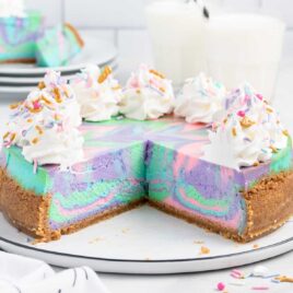 a close up shot of Unicorn Cheesecake with multiple slices taken out on a plate
