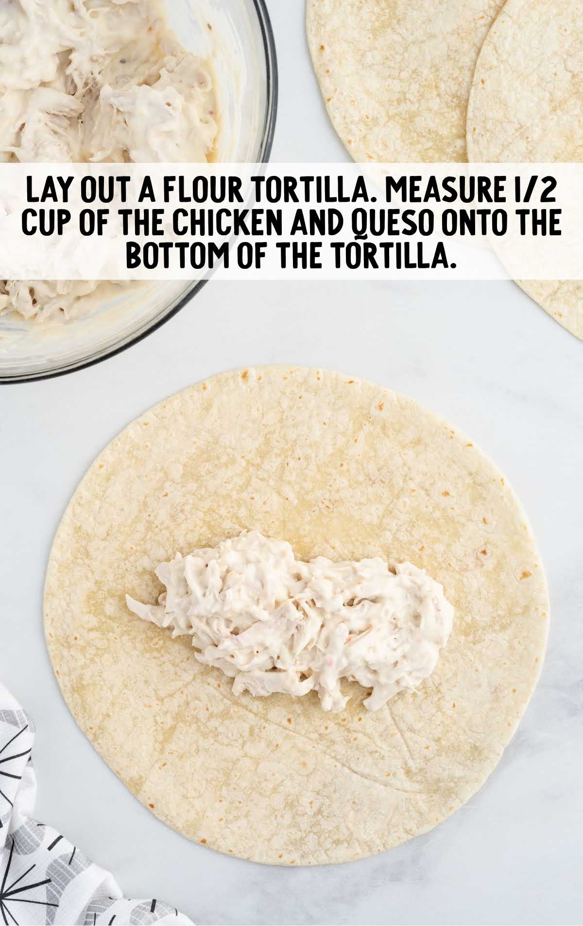 chicken and queso put on the bottom of the tortilla