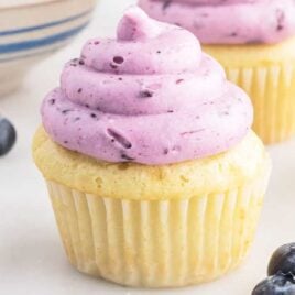 a close up shot of Blueberry Cream Cheese Frosting on a cupcake