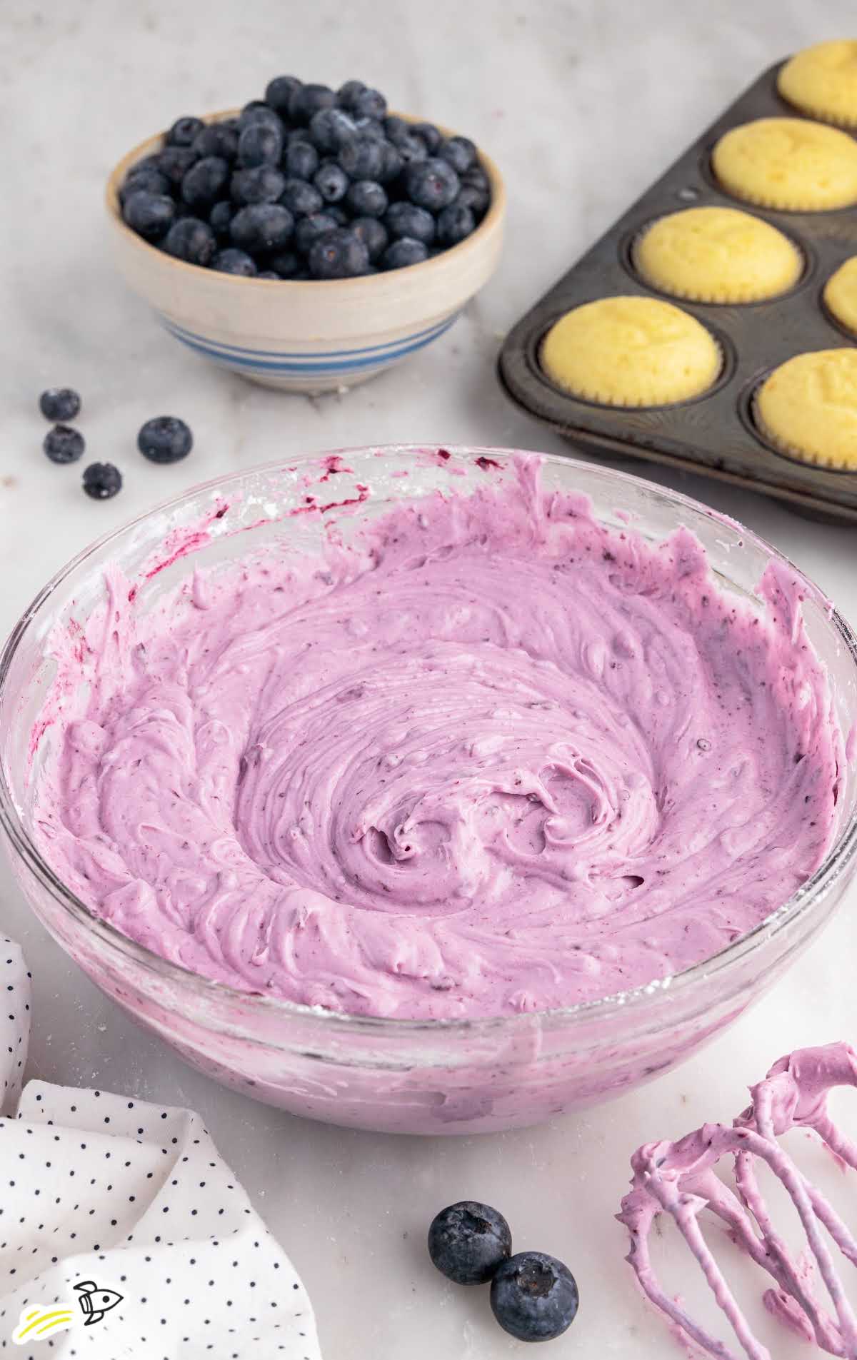 a close up shot of Blueberry Cream Cheese Frosting in a bowl