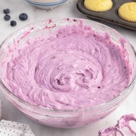 a close up shot of Blueberry Cream Cheese Frosting in a bowl
