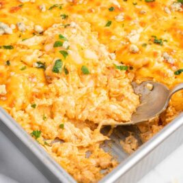 a close up shot of Buffalo Chicken Casserole with a spoon grabbing a piece
