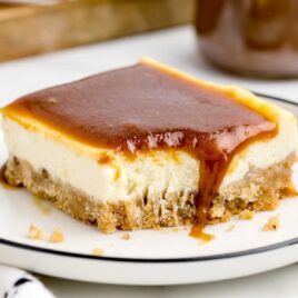 a close up shot of a slice of Caramel Cheesecake Bar on a plate with a bite taken out of it