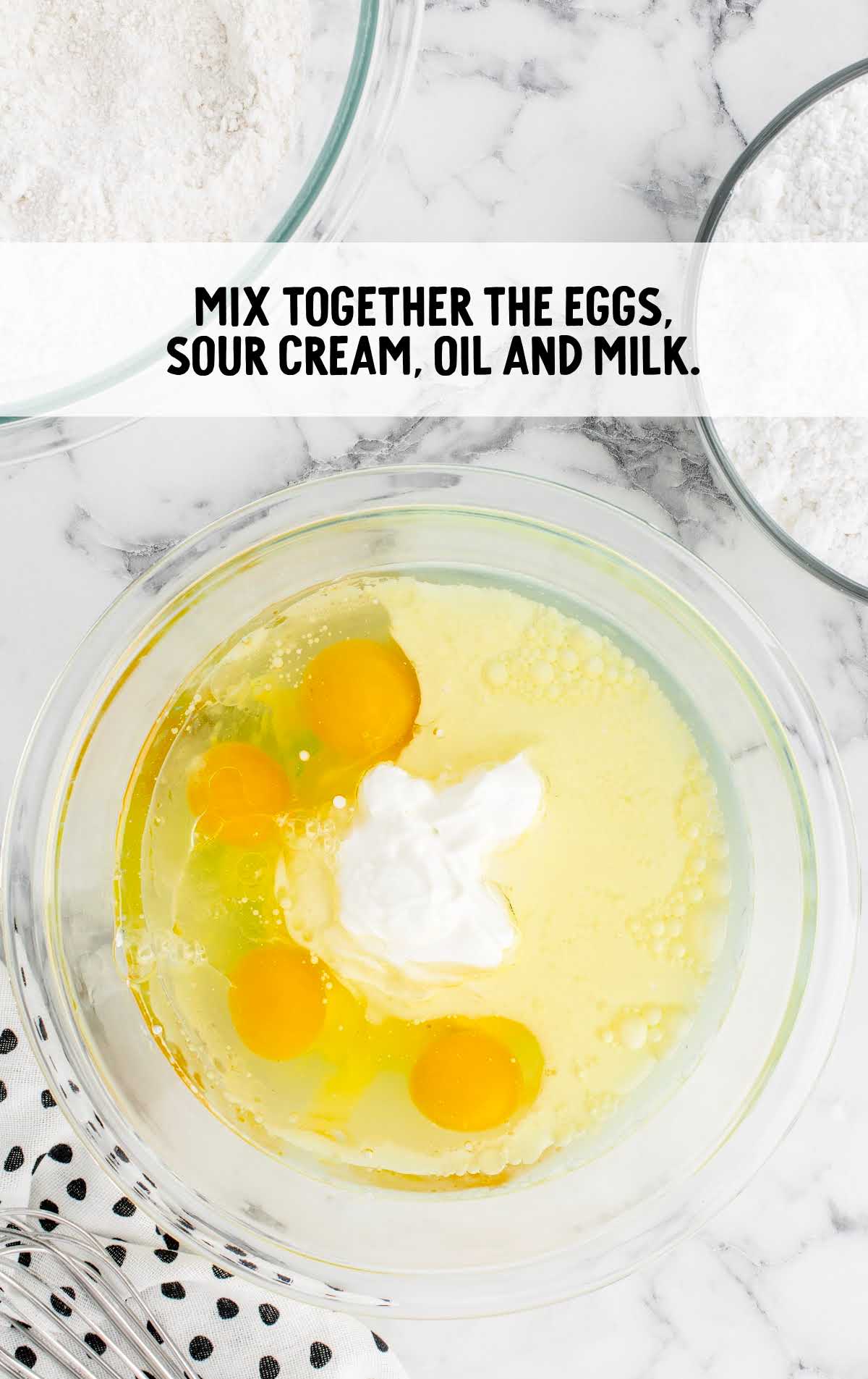 eggs, sour cream, oil, and milk combined in a bowl