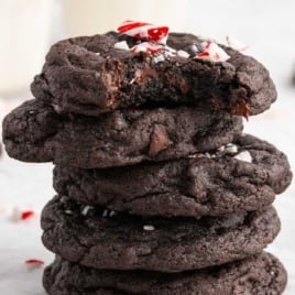 Stack of thick, fudgy chocolate peppermint cookies topped with crushed candy canes.