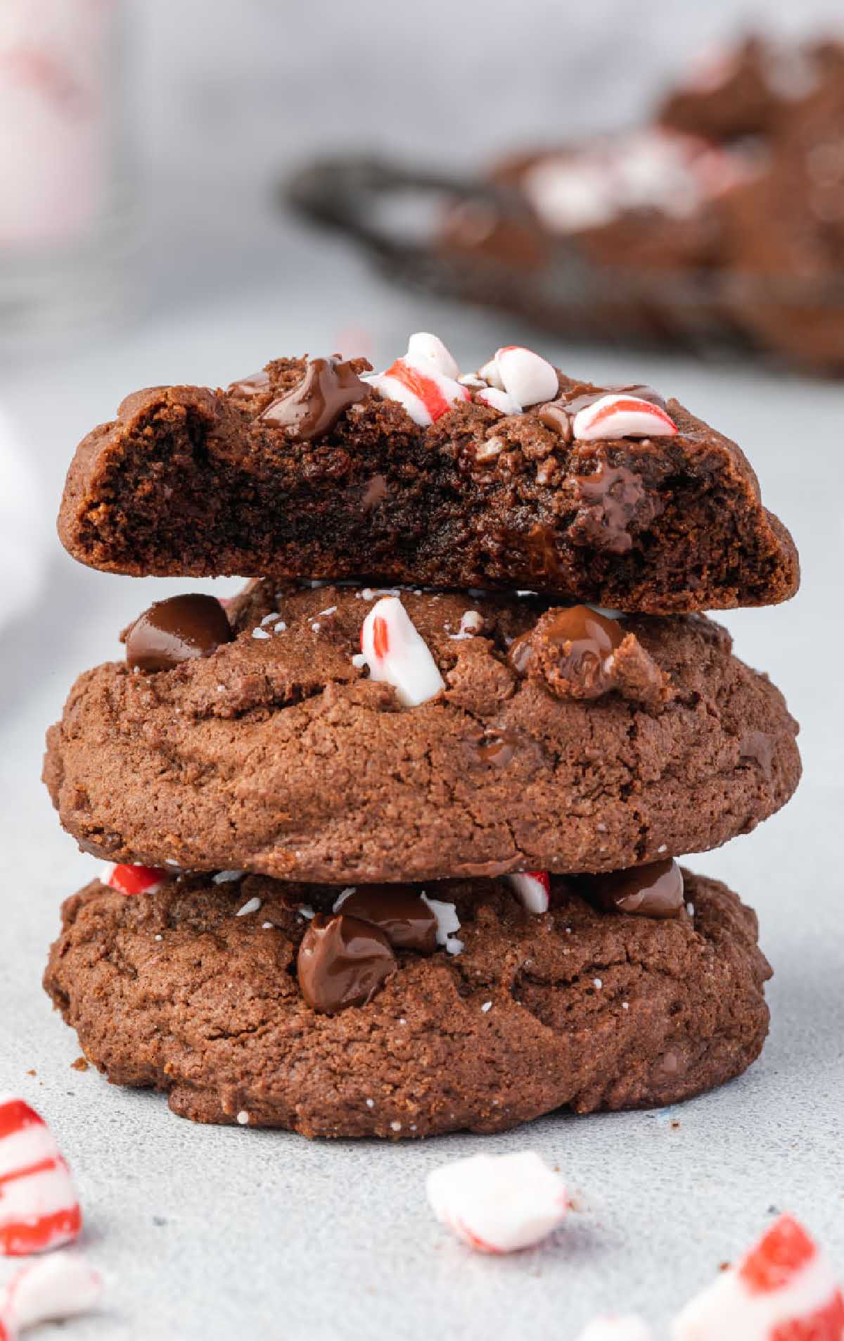 a close up shot of Chocolate Peppermint Cookies stacked on top of each other with one having a bite out of one