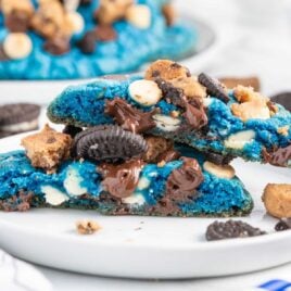 a close up shot of a Cookie Monster Cookie split in half on a plate