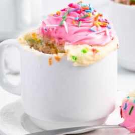 a close up shot of Cupcake in a Mug with a piece in a spoon