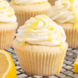 a close up shot of Lemon Drizzle Cupcakes on a cooling rack