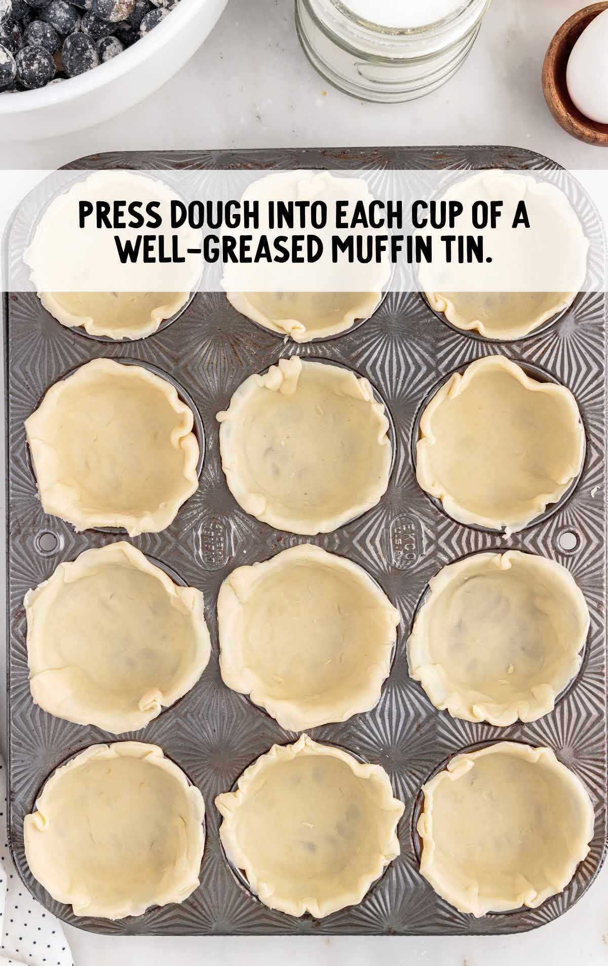 dough pressed into each greased muffin tin