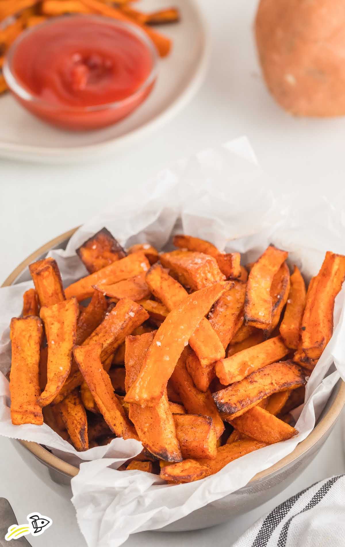 a close up shot of Air Fryer Sweet Potato Fries in a basket