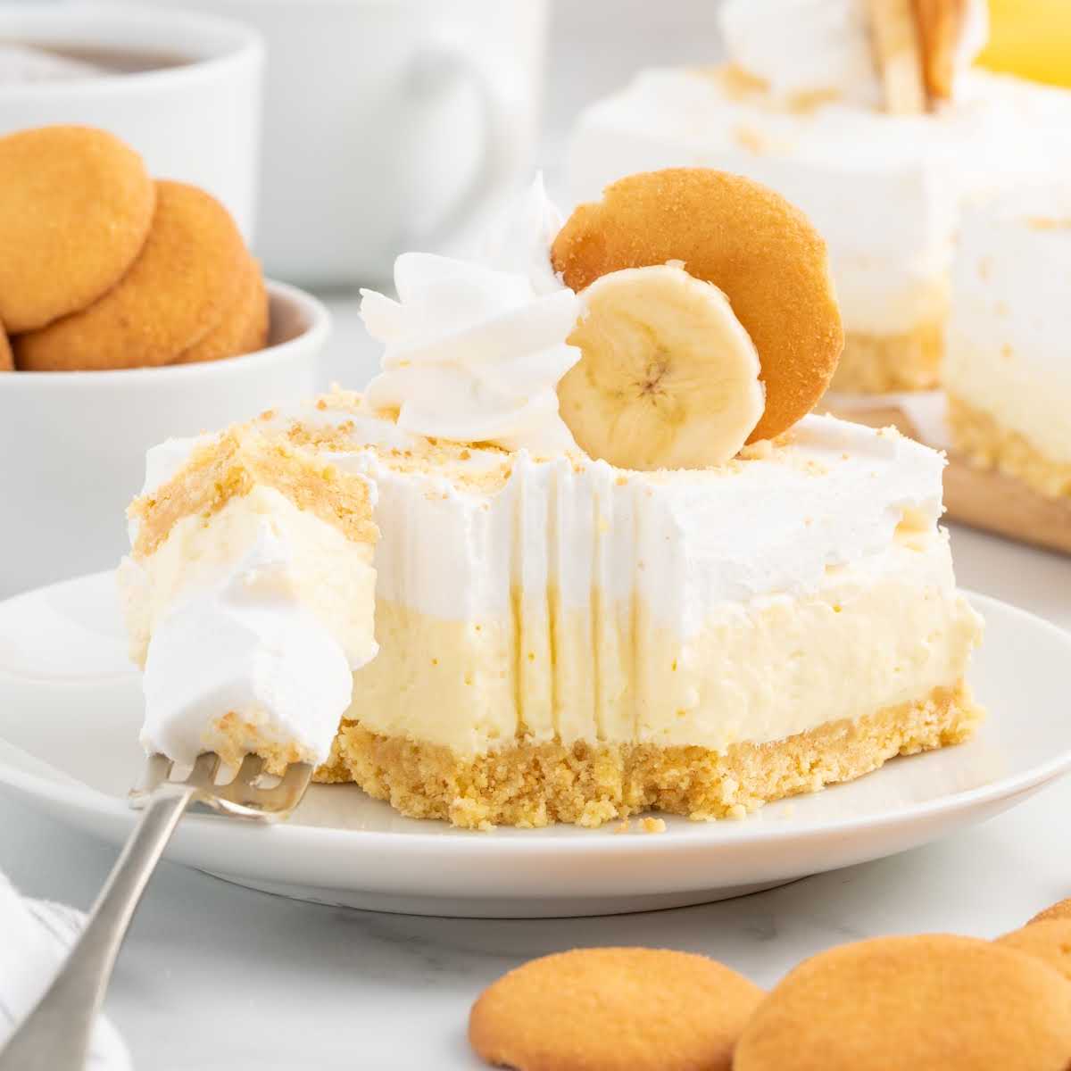 a close up shot of a piece of Banana Cheesecake Bars with a bite taken out of it