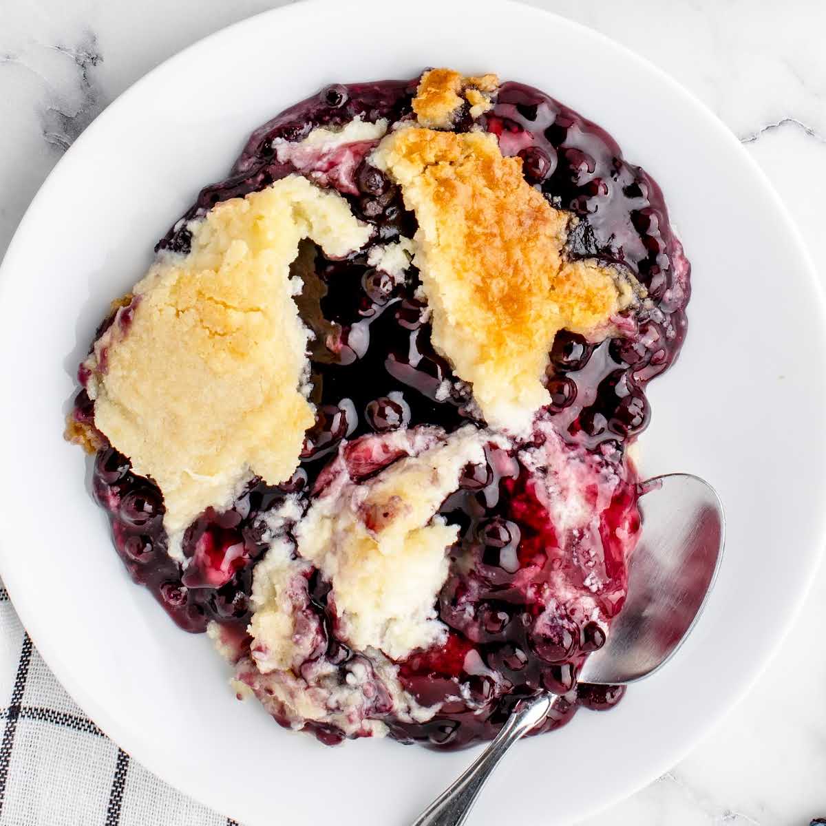 overhead shot of a piece of Blueberry Cheesecake Dump Cake on a plate