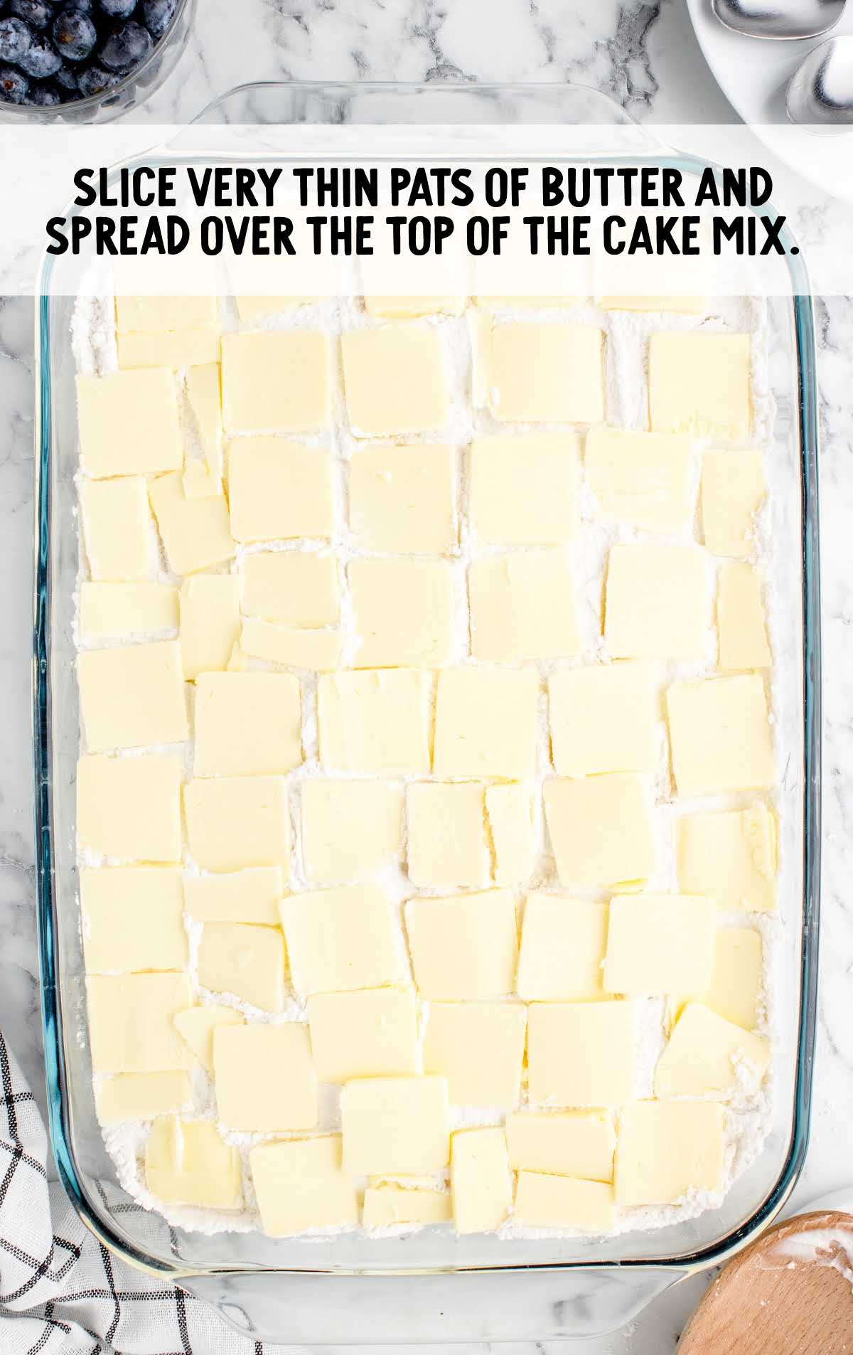 slices of butter spread over the top of the cake mix