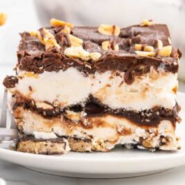 a close up shot of a piece of Buster Bar Ice Cream Cake on a plate