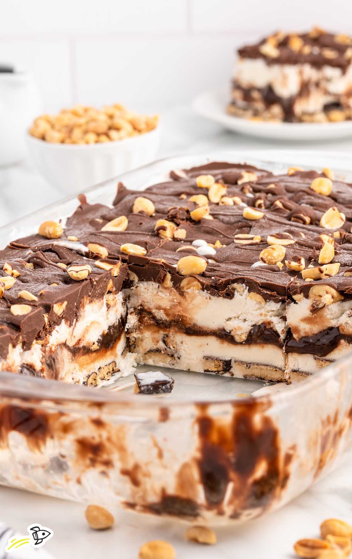 close up shot of Buster Bar Ice Cream Cake in a baking dish with a couple of pieces taken out
