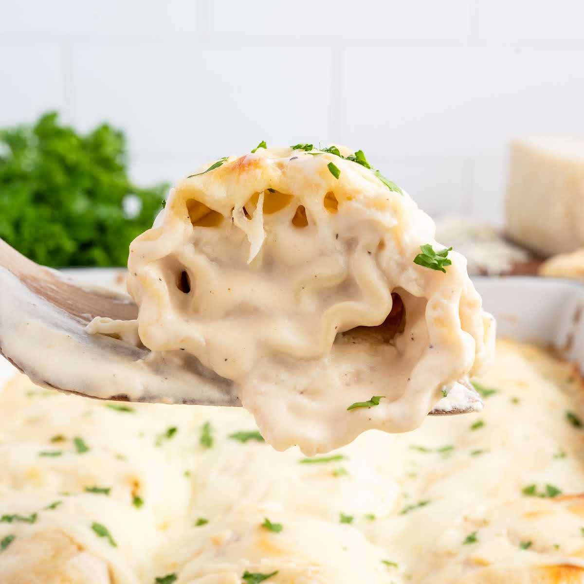 a close up shot of a fork with a piece of Chicken Lasagna Roll Ups