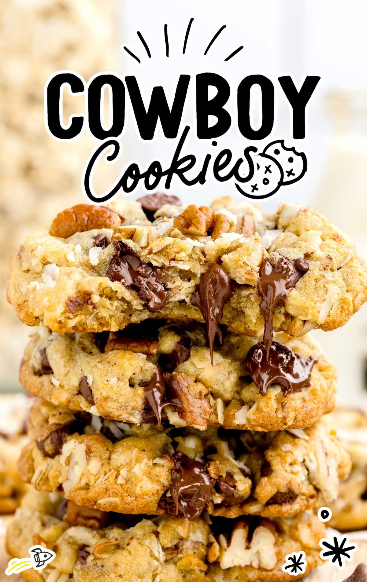 a close up shot of Cowboy Cookies stacked on top of each other with one having a bite taken out of it