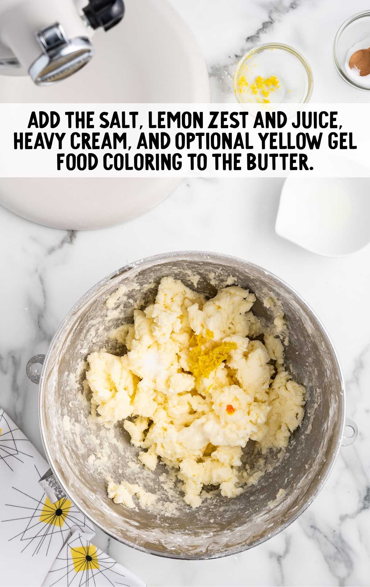 salt, lemon zest and juice, heavy cream, and yellow food coloring added to the butter mixture