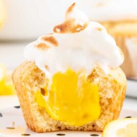 a close up shot of a Lemon Meringue Cupcake with a bite taken out of it
