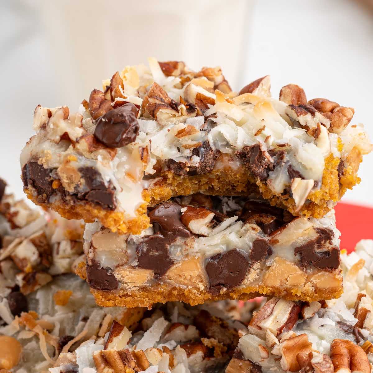 Bite taken from a 7 layer bar revealing the gooey chocolate, coconut, and graham cracker layers.