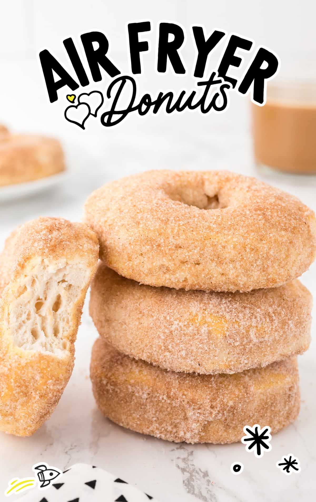 Air Fryer Donuts stacked on top of each other with a bite taken out of the top donut