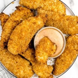 overhead shot of chicken tenders on a plate with a bowl of dipping sauce