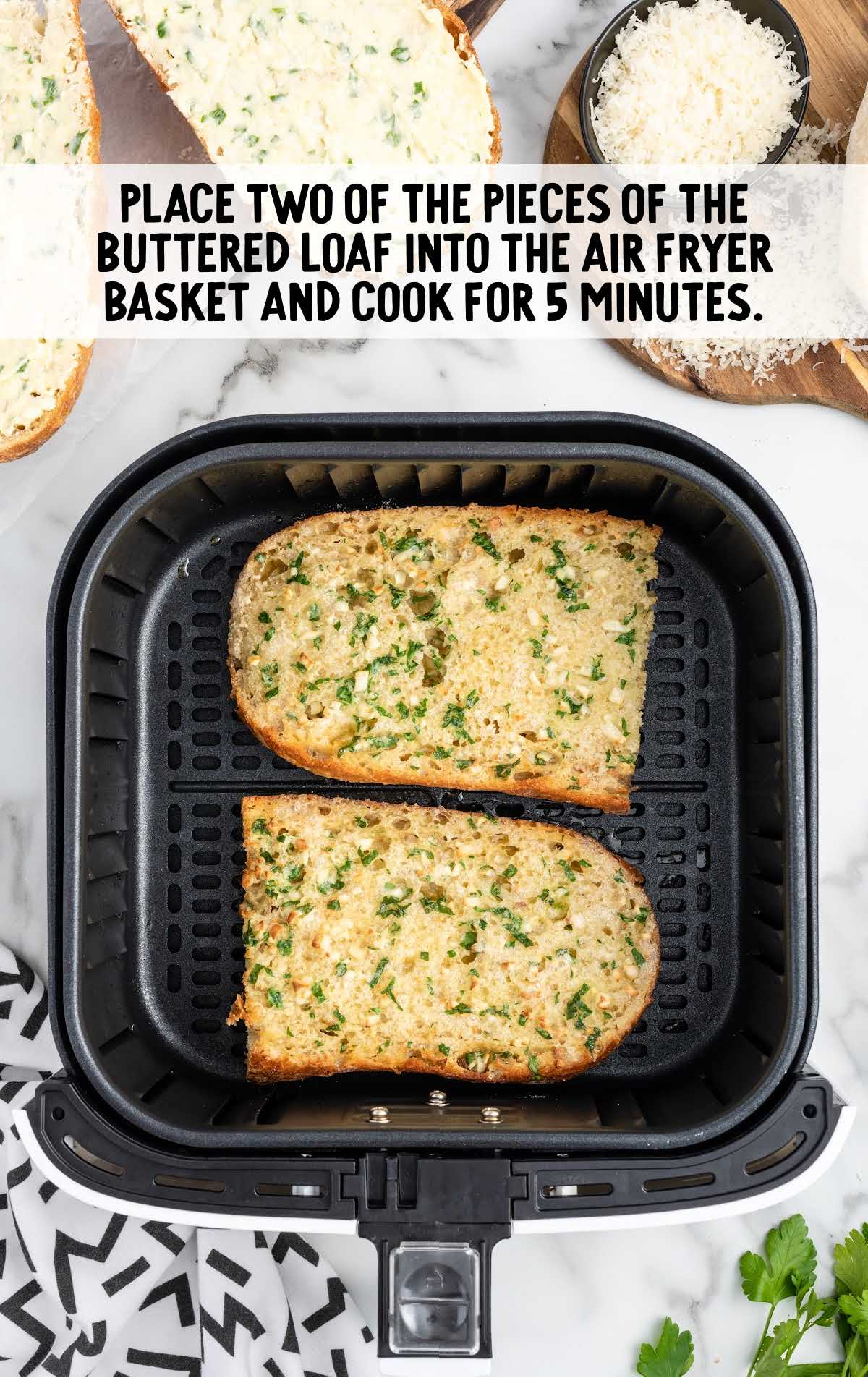 two pieces of garlic bread placed in a air fryer