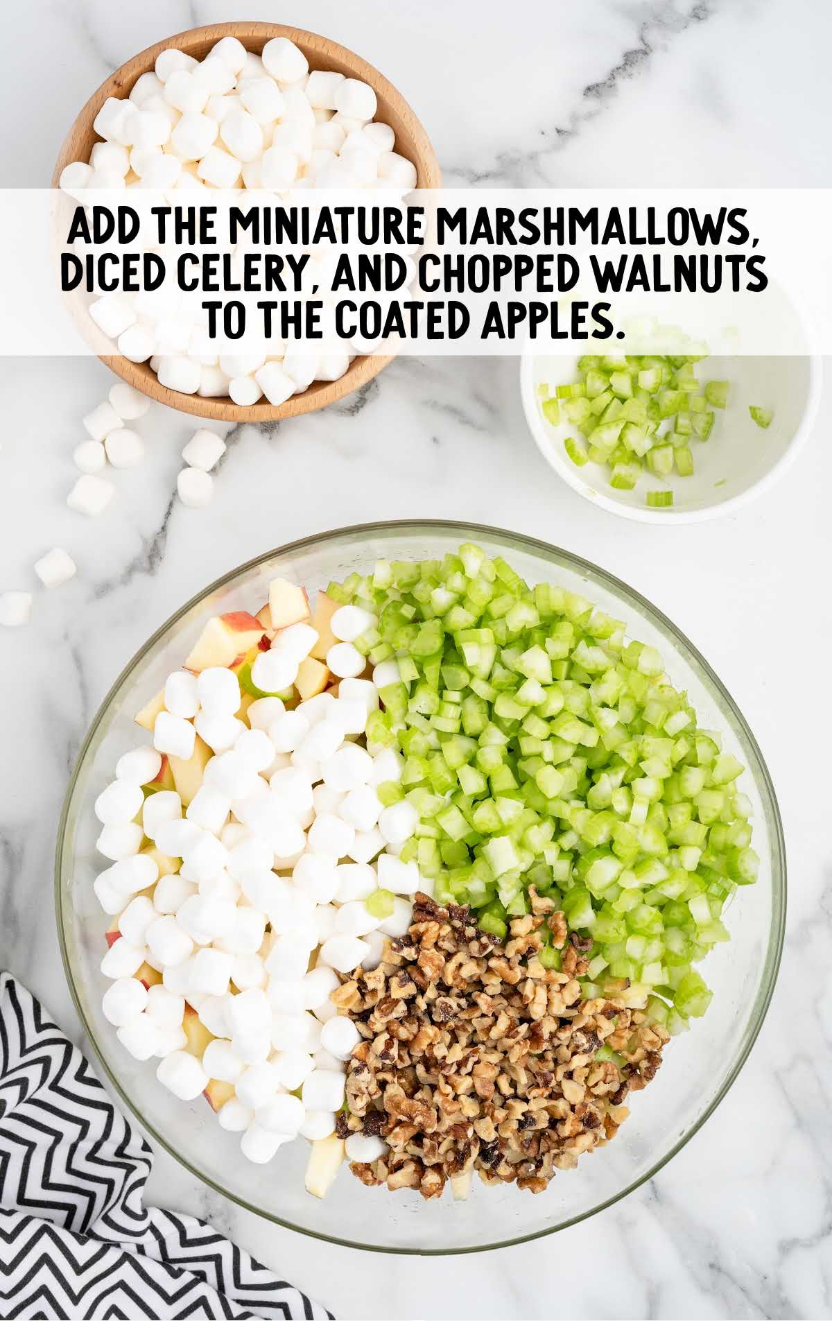 miniature marshmallows, diced celery, and chopped walnuts added to the coated apples in a bowl