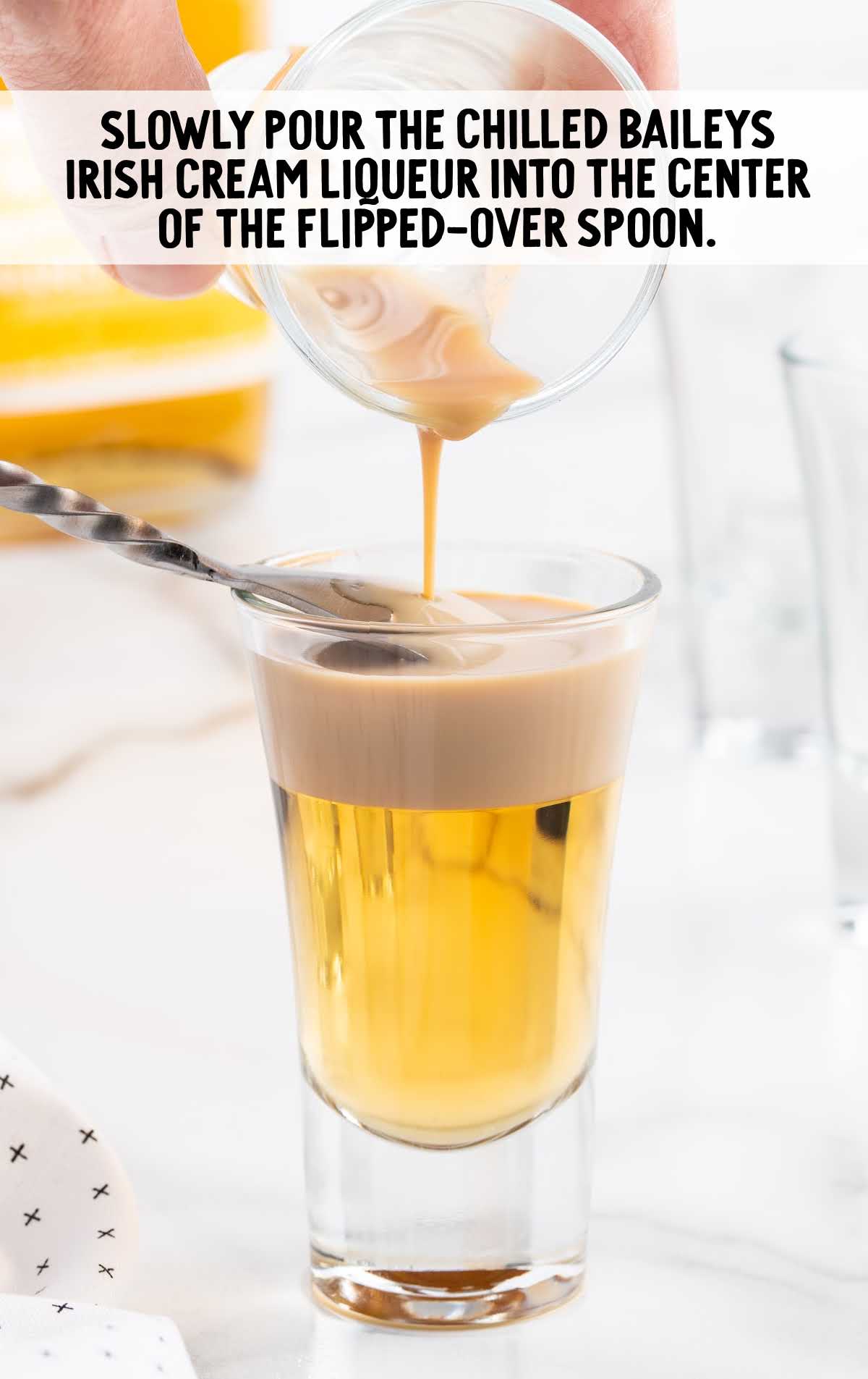 Baileys Irish cream liqueur poured into the center of the flipped over spoon