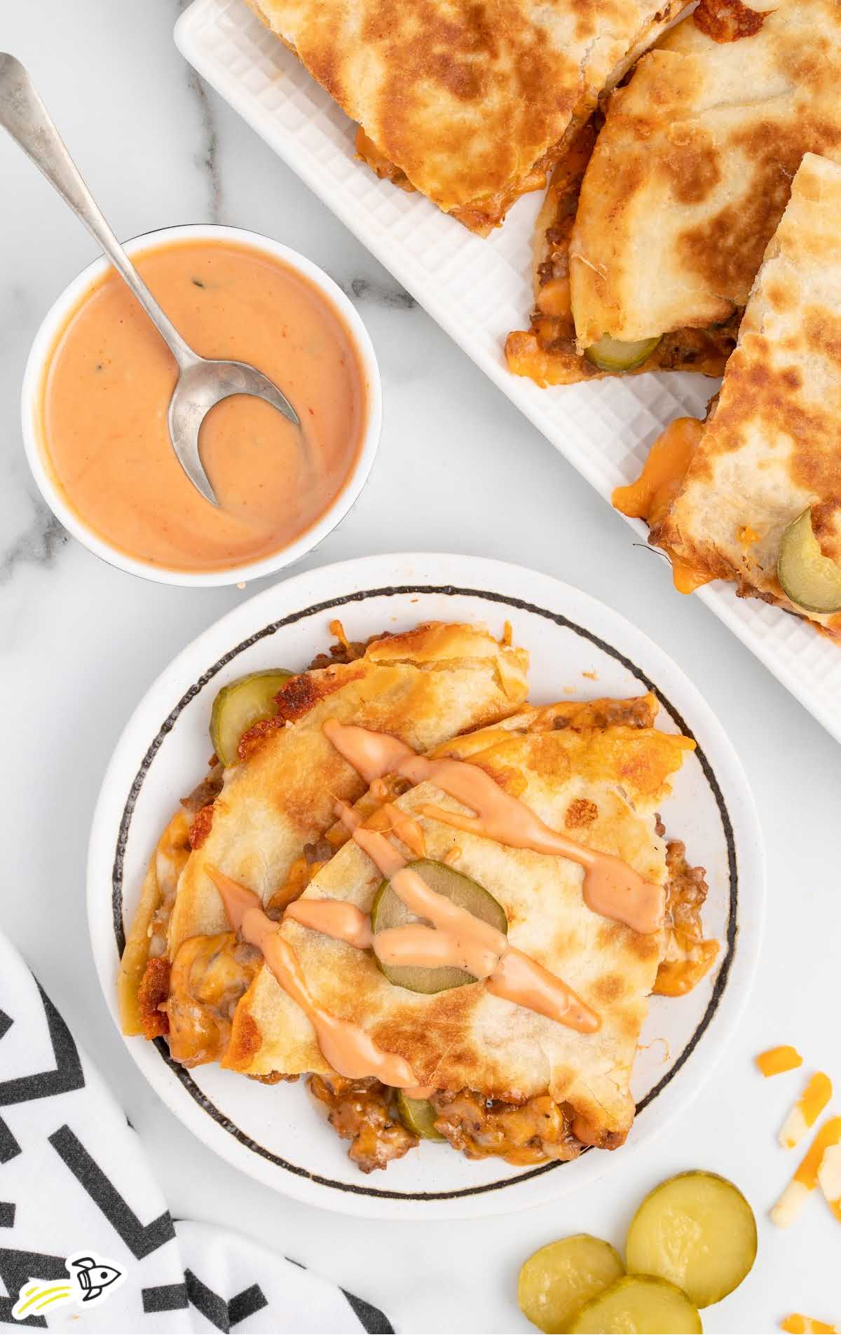 overhead shot of Cheeseburger Quesadilla drizzled with burger sauce on a plate