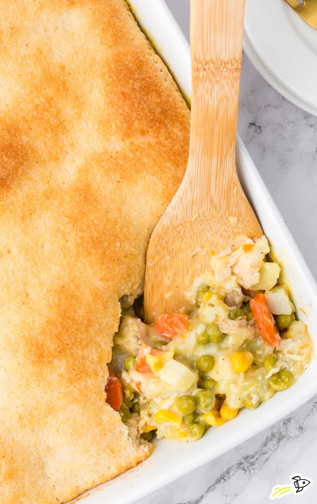 overhead shot of a piece of Easy Chicken Pot Pie being picked up by a wooden spoon
