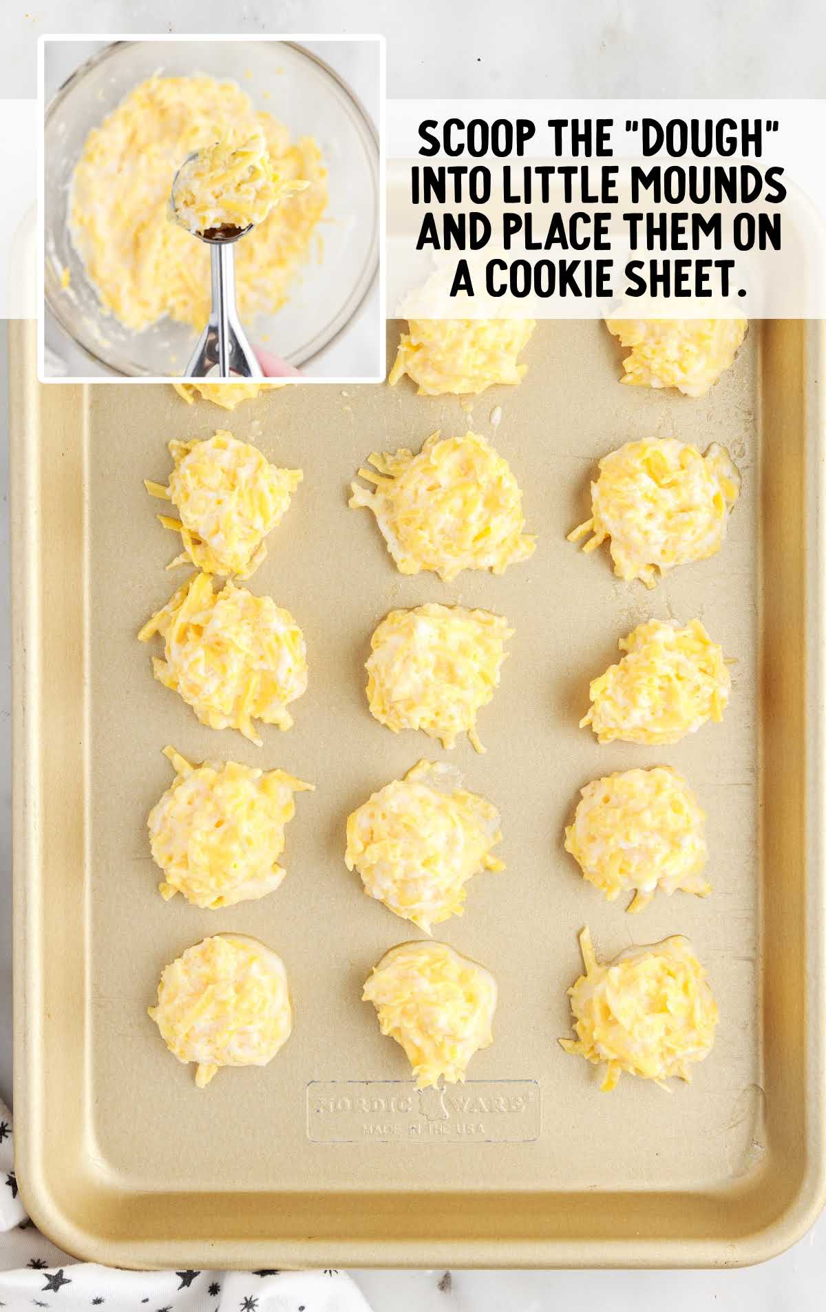 cheese dough scooped out with a cookie scooper and placed on a baking sheet