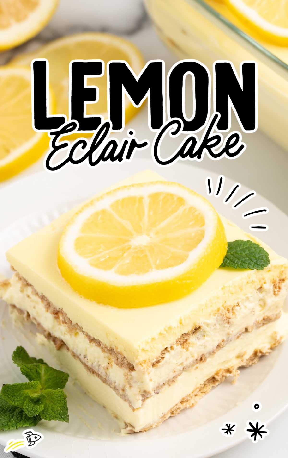 a close up shot of a slice of Lemon Eclair Cake on a plate topped with a sliced lemon