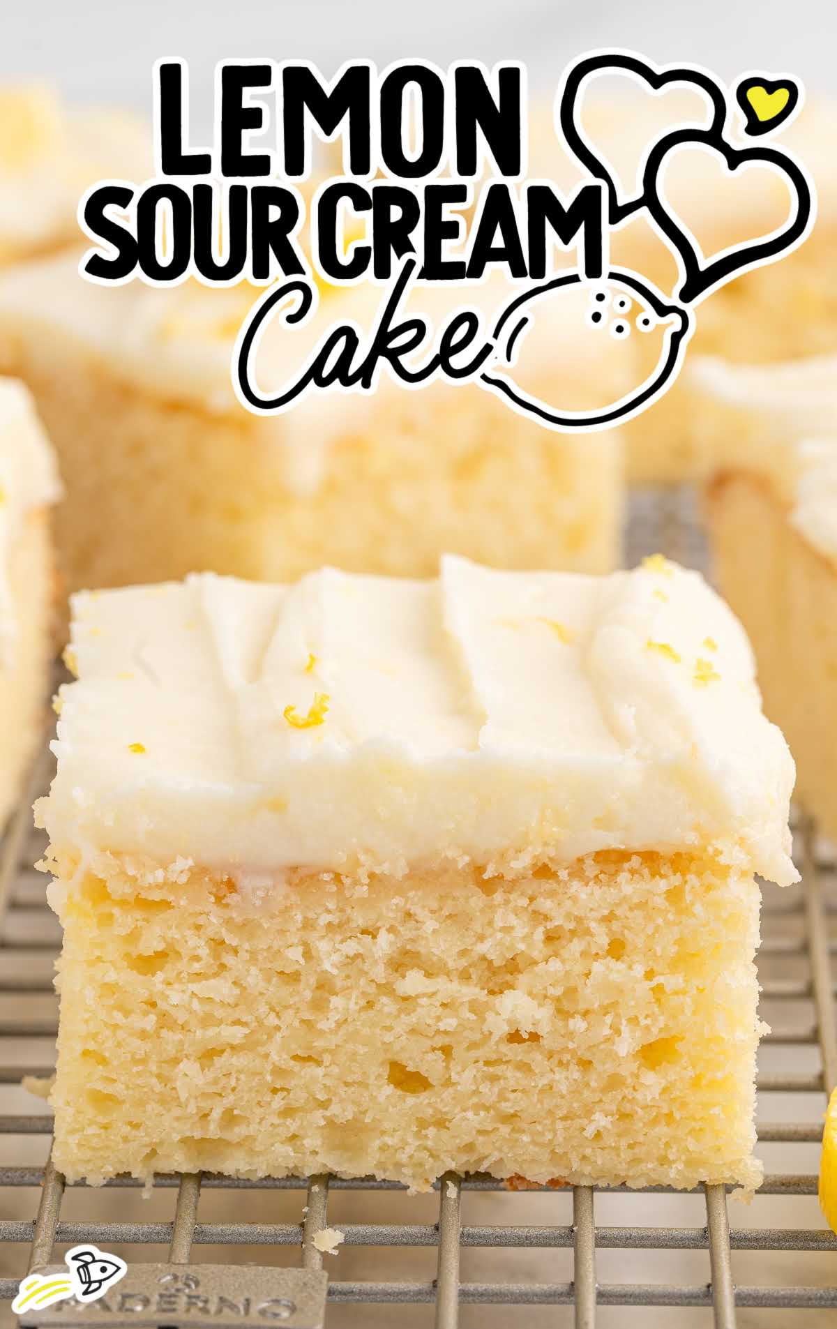 Front view of lemon sour cream cake slice with rich white frosting and bright texture.
