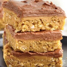 a close up shot of Lunch Lady Peanut Butter Bars stacked on top of each other on a plate