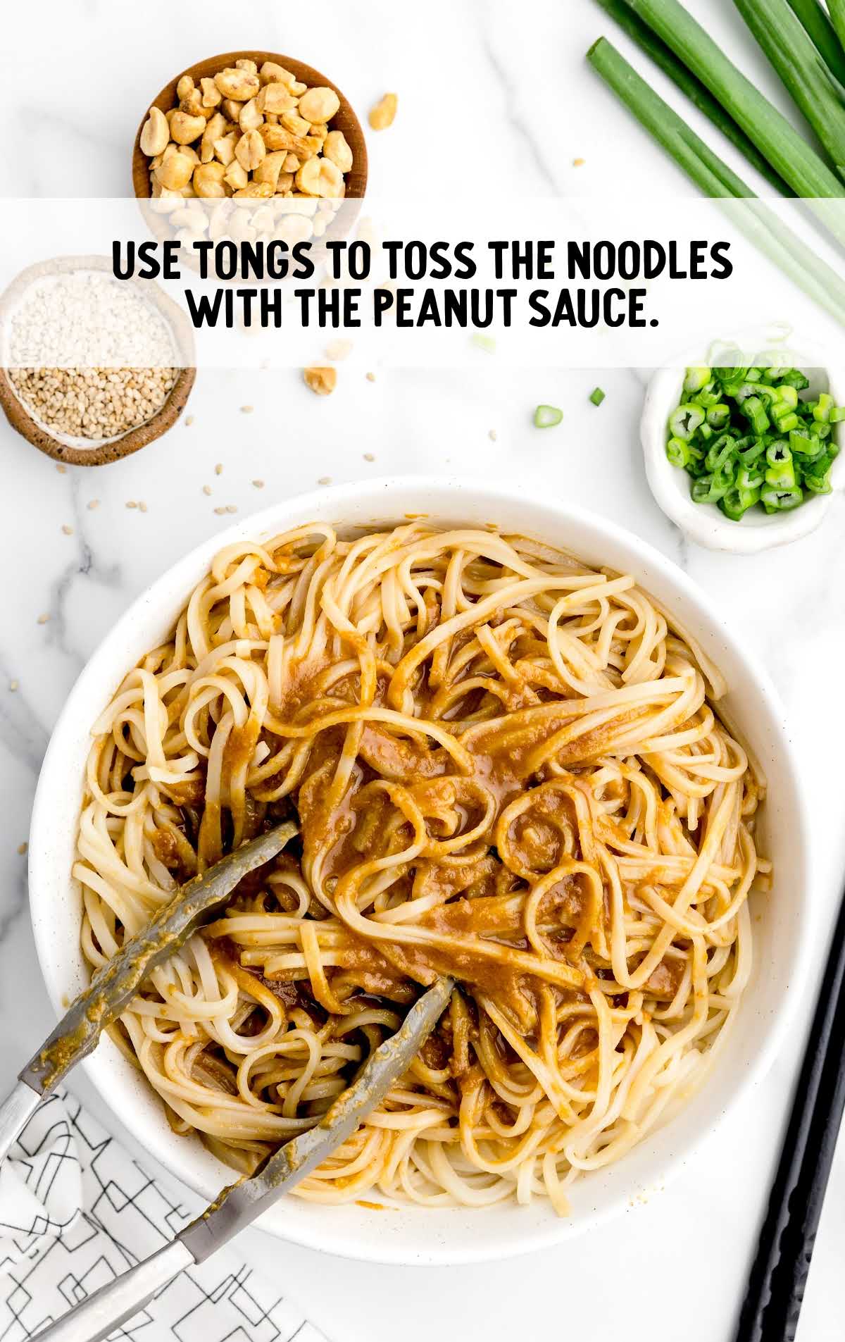 tongs used to toss noodles with the peanut sauce