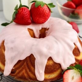 close up shot of a cake topped with strawberry glaze and strawberries