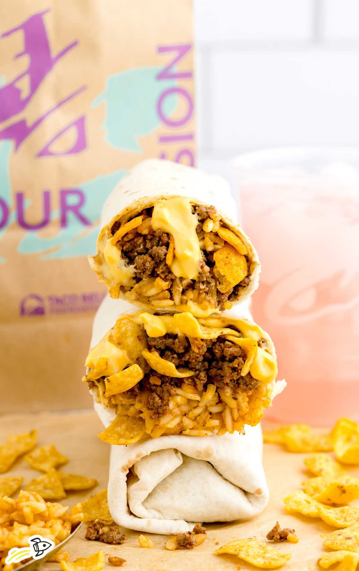 Taco Bell Frito Burrito stacked on top of each other with a Taco Bell bag in the back