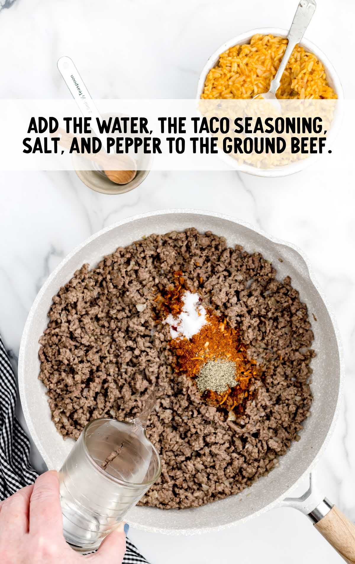 water,  taco seasoning, salt, and black pepper added to the ground beef in a skillet